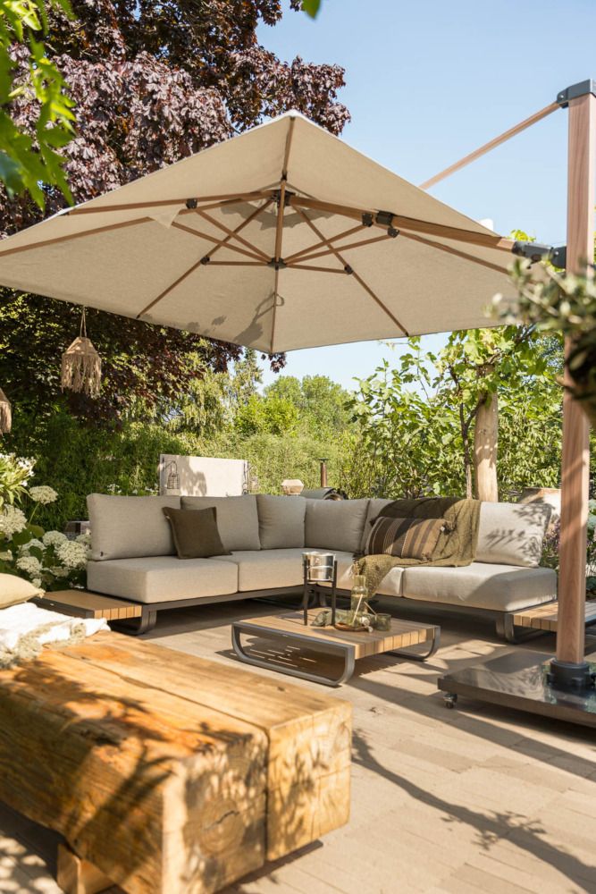  Vooraanzicht van een overkapping met een industri&euml;le tuinstijl, voorzien van een moderne platform loungeset en loungetafel.