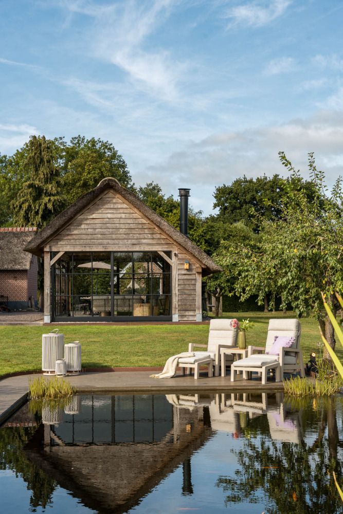 Vooraanzicht van een grote tuin met een landelijke tuinstijl, voorzien van een wicker tuinset en wicker stoel-bank loungeset.