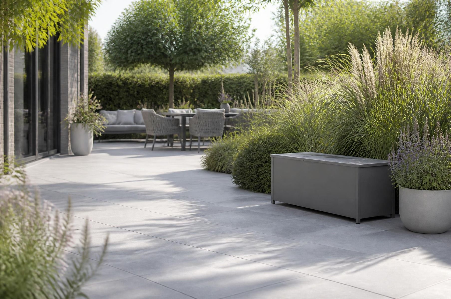 Grijze Lifestyle kussenbox van 210 x 110 cm op een strak terras naast een loungeset.