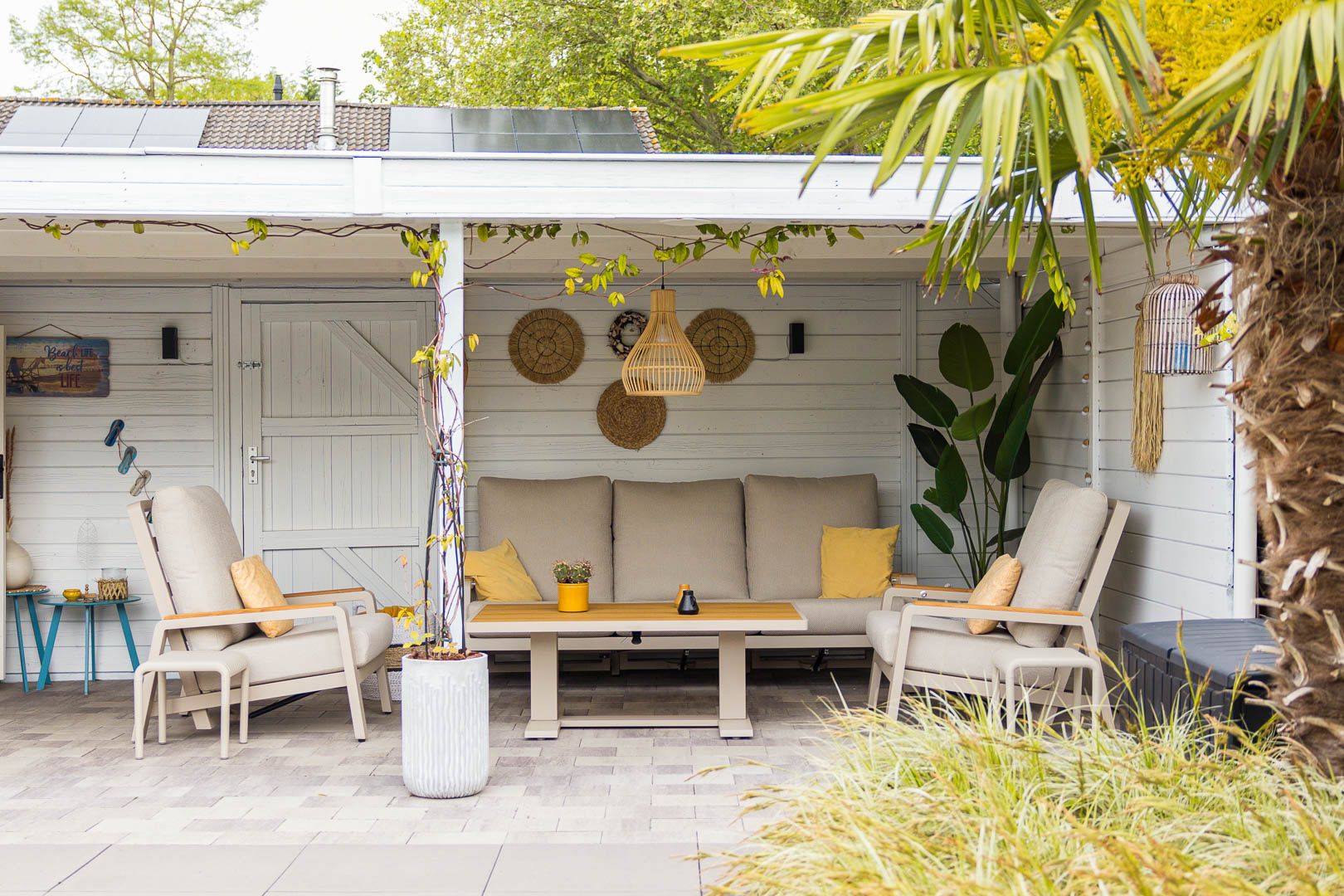 Ruime overkapping met loungeset en bar in de achtertuin