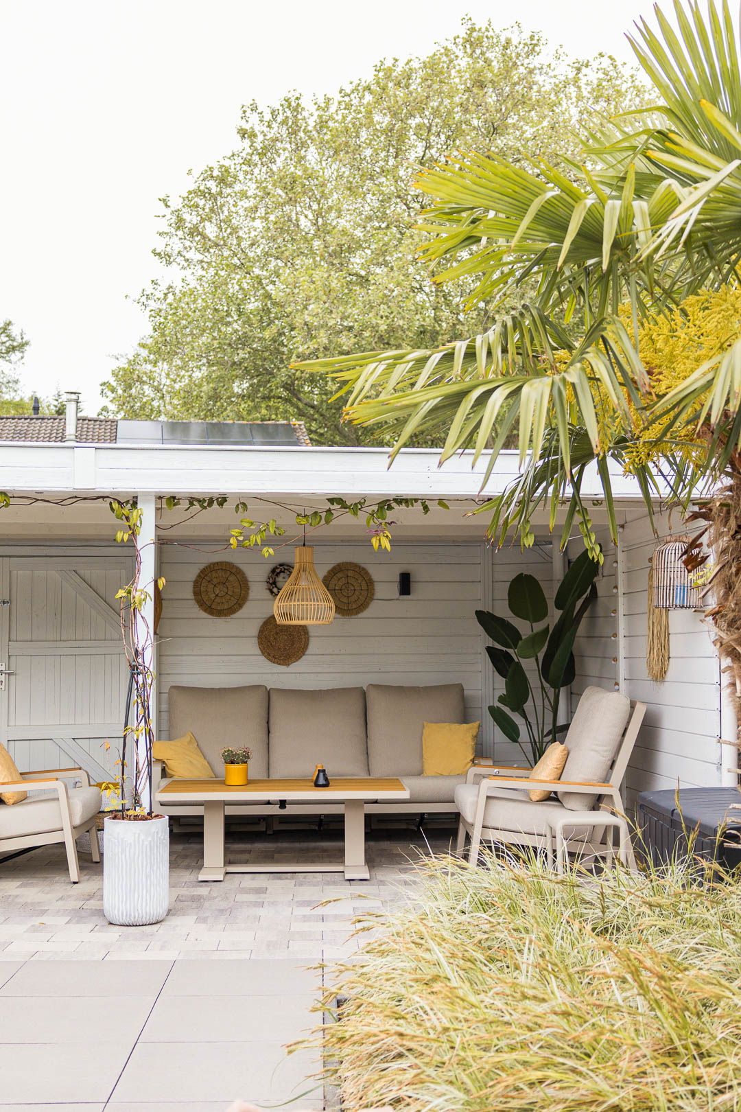 Overkapping met lichte loungeset en zomerse details