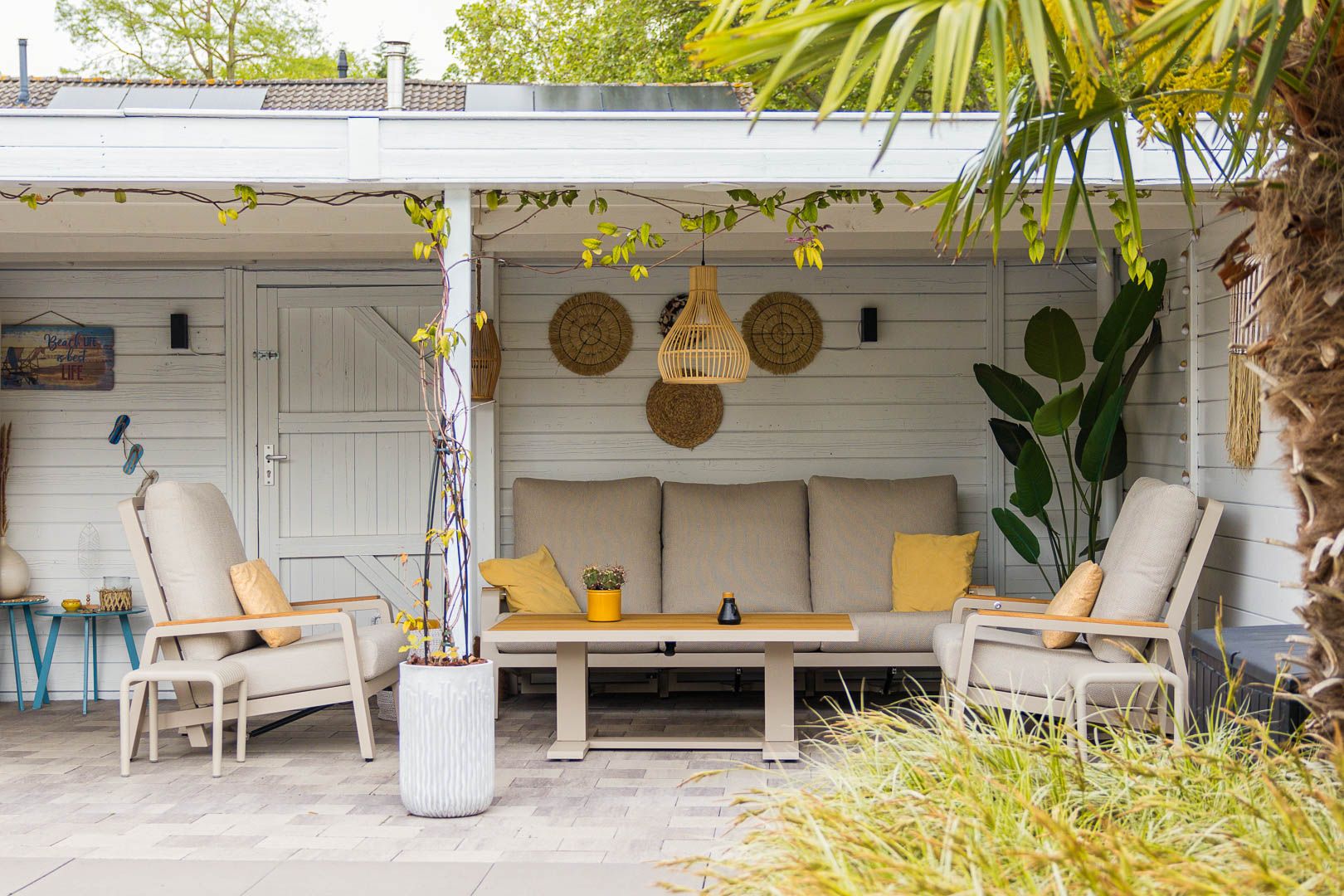 Overdekte loungeplek met moderne loungeset in de tuin van Dionne en Ad