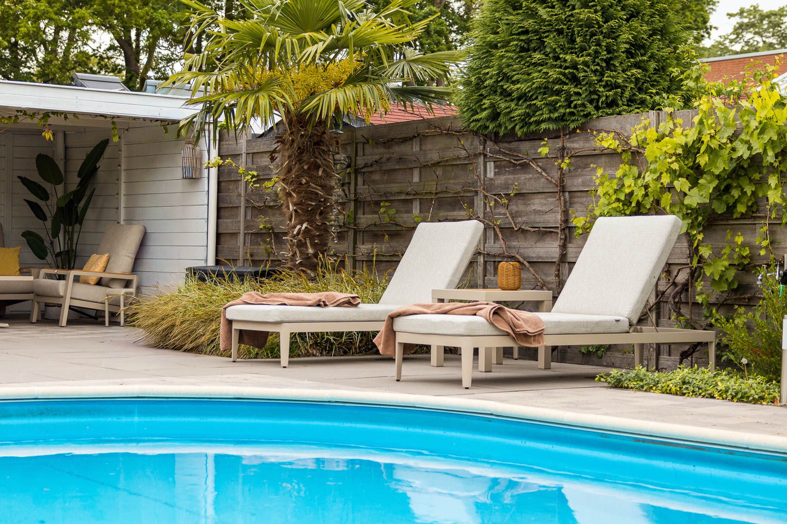 Achtertuin met zwembad, ligbedden en loungeset