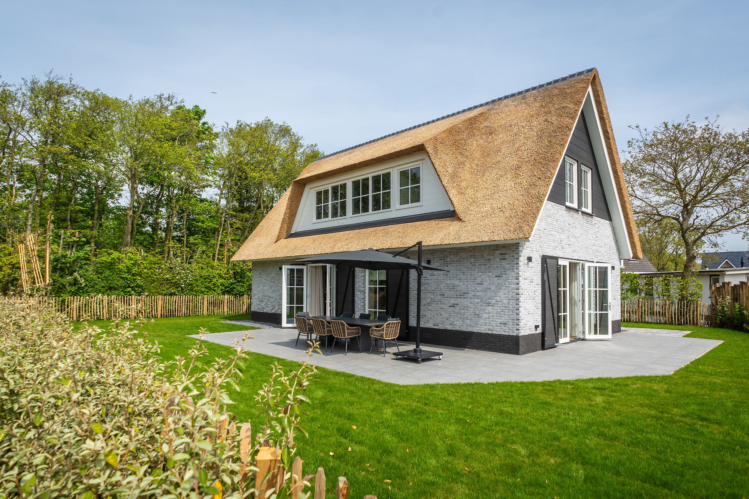 So What – Zijaanzicht bungalow met een tuinset op het terras.