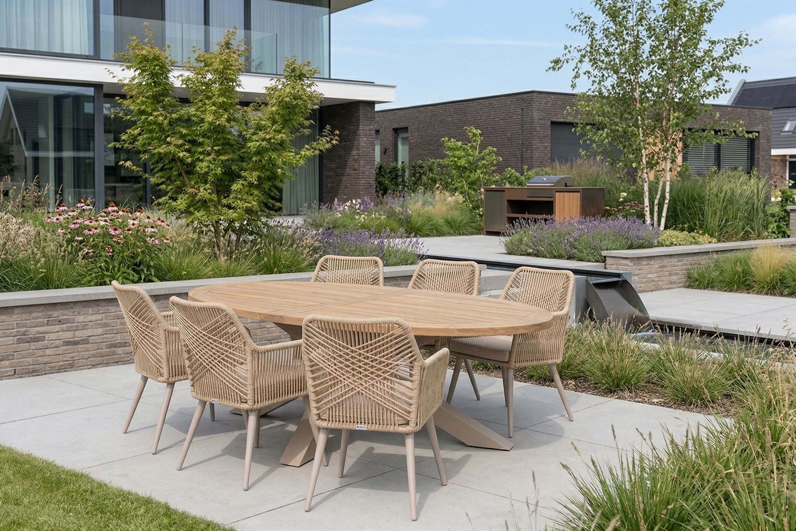 Wicker dining tuinstoel op modern terras met grote tegels en plantenbakken in een strakke nieuwbouwwijk.