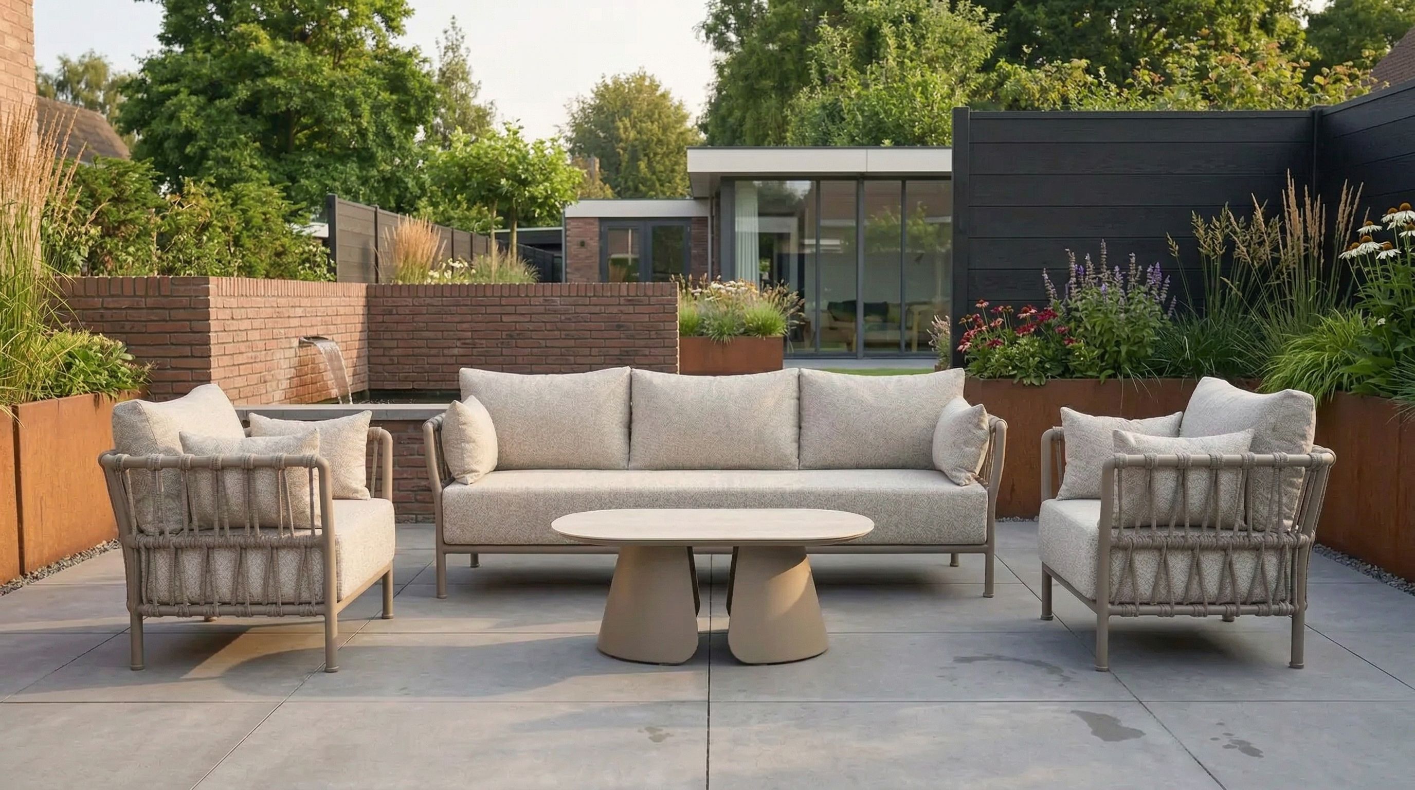 Weerbestendige aluminium loungeset met rope-vlechtwerk en lichtgrijze kussens op een modern terras.