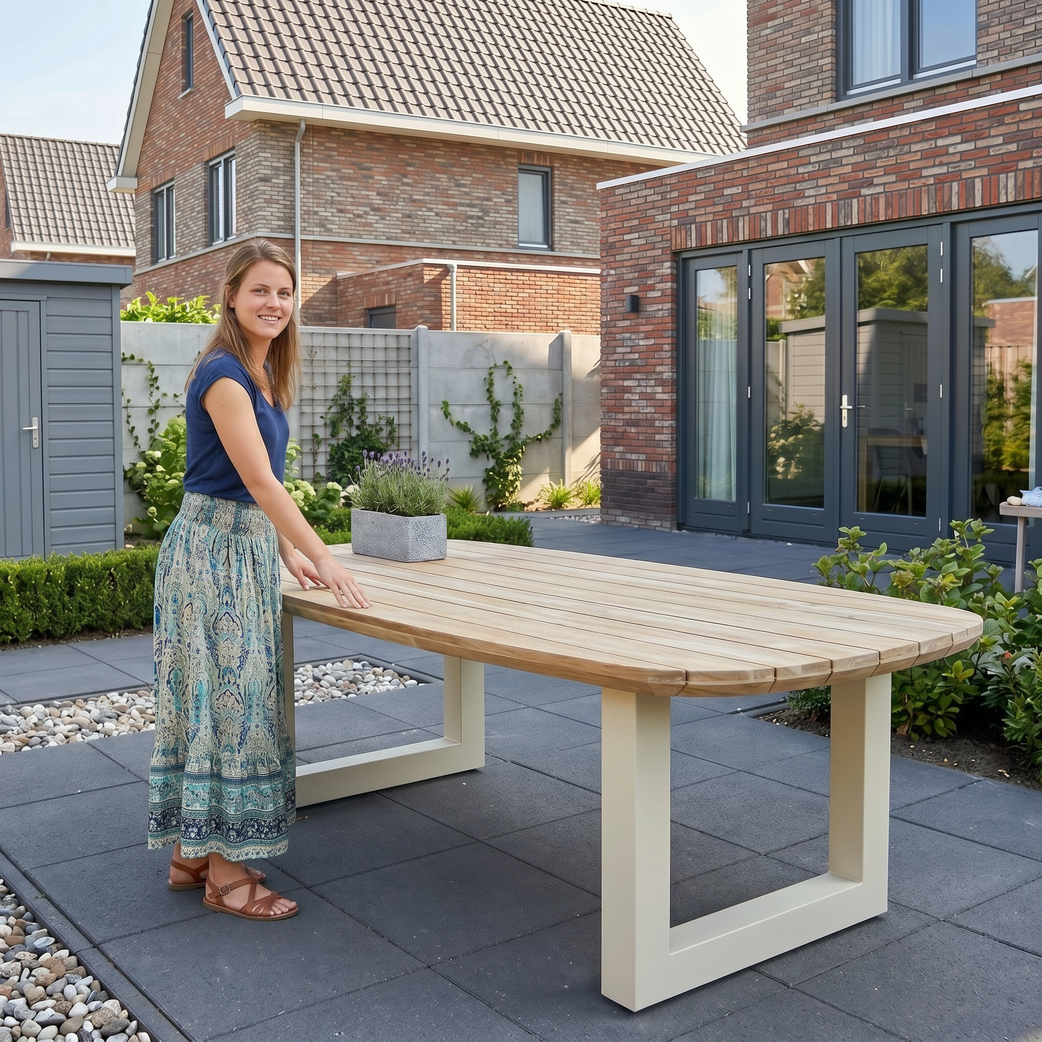 Een vrouw staat glimlachend naast een schone, houten tuintafel die na het afspoelen buiten staat te drogen op het terras.