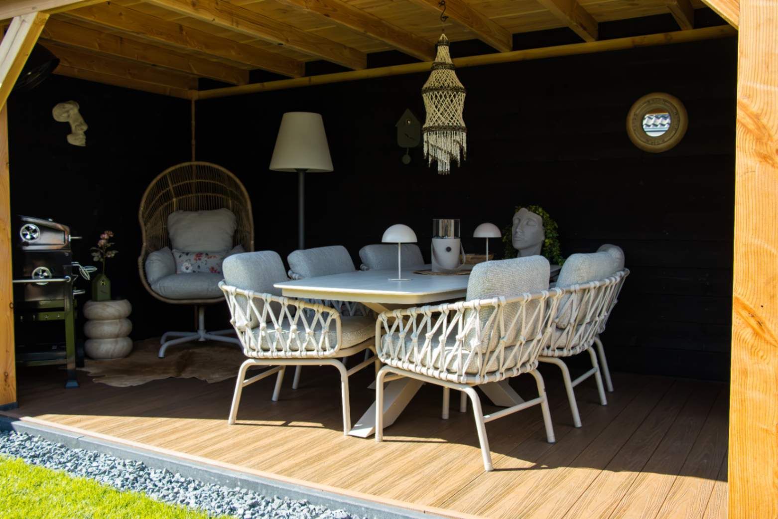 Lichte low dining stoelen en tafel in de schaduw onder de overkapping