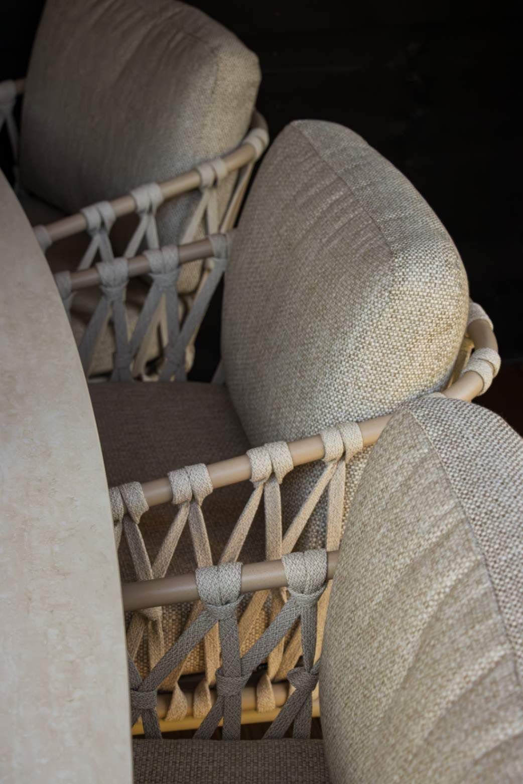 Detail van een lichte low dining stoel met een comfortabel kussen