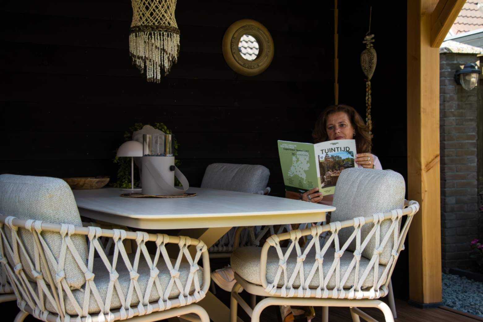 Lichte low dining tuinset onder de overkapping in de tuin van Ingrid