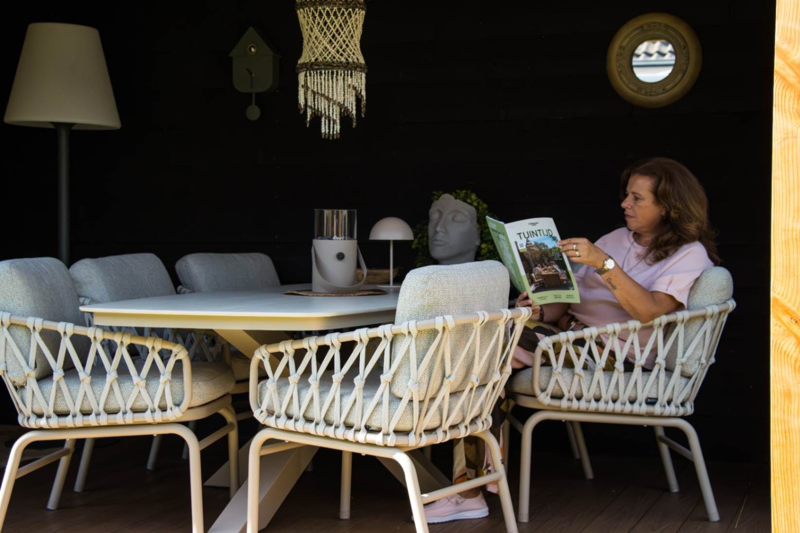Sfeervolle overkapping met een lichte low dining set en verlichting