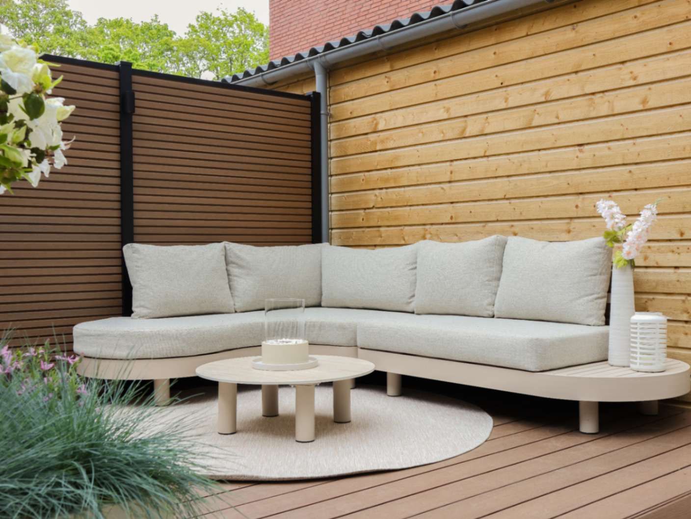 Beige loungeset met lichte kussens en ronde loungetafel