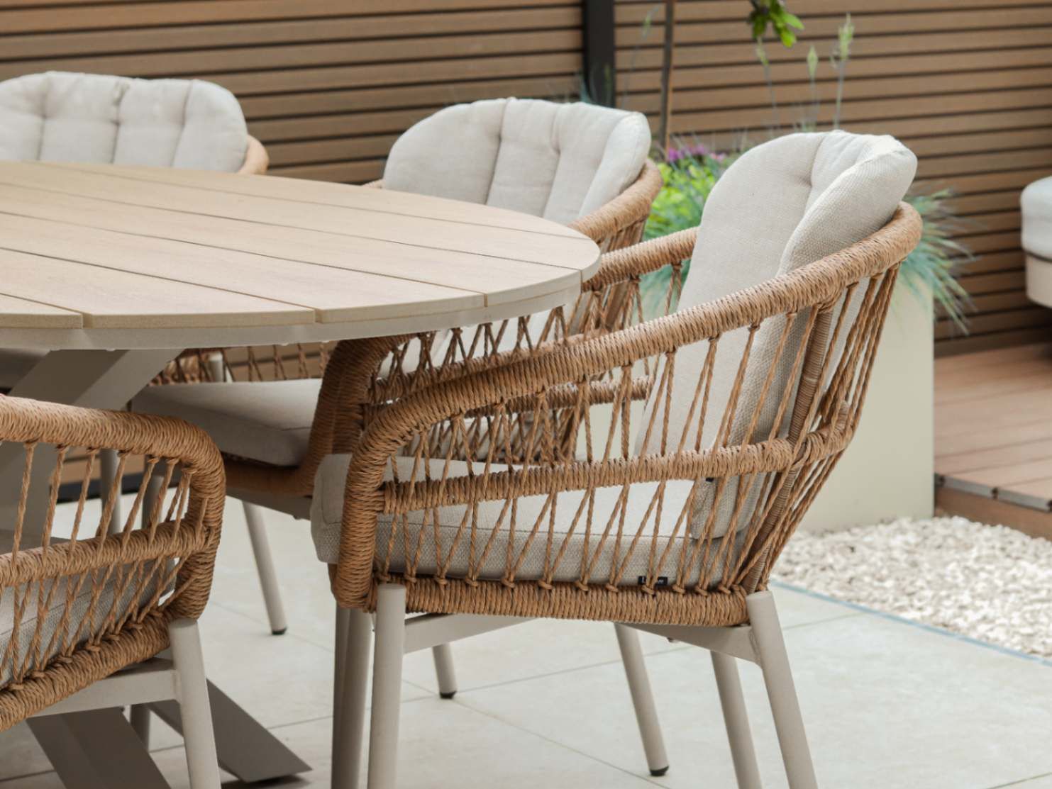 Detail van een beige rope tuinstoel aan de eettafel