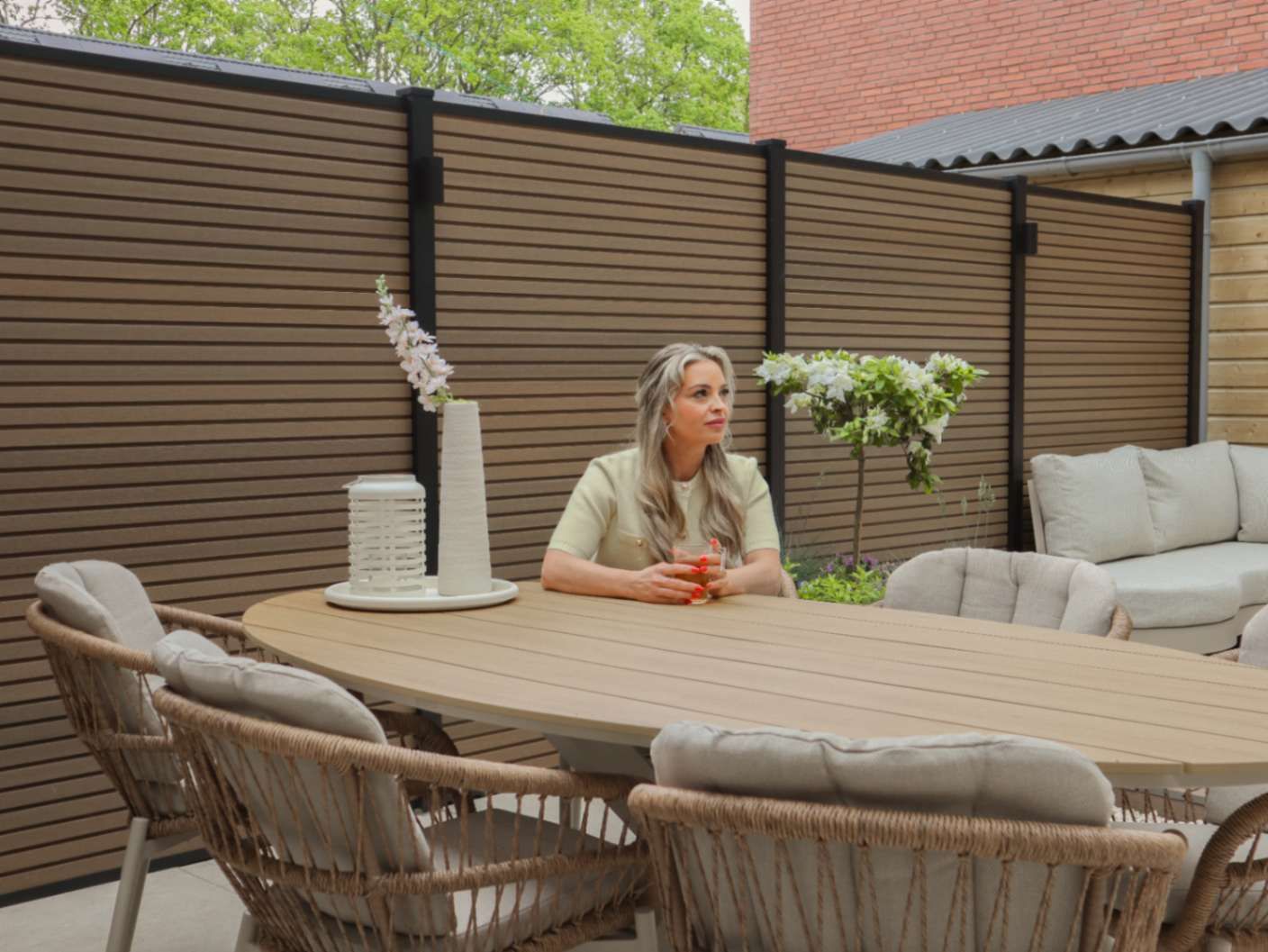 Nicole aan de beige dining tuinset in haar achtertuin
