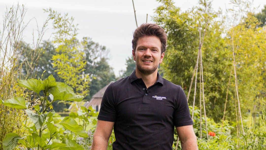 Man tussen groenten en kruiden in een moestuin