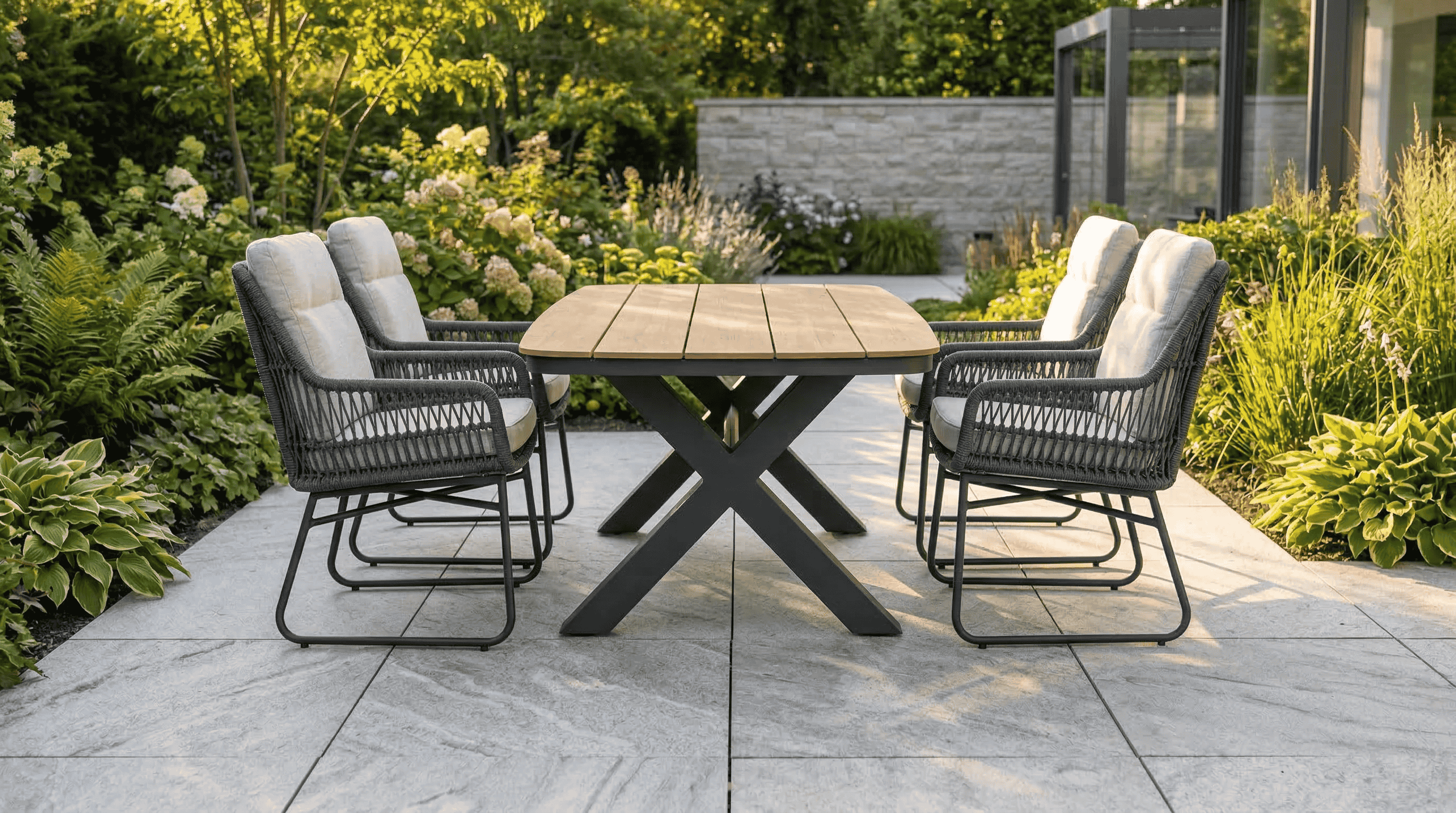 Aluminium dining tuinset op modern terras met grote tegels en plantenbakken in een strakke nieuwbouwwijk.