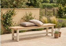 Twee vrouwen aan een moderne houten picknicktafel met witte banken in een stijlvolle tuin