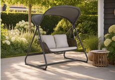 Moderne schommelbank met zonnedak en kussens in de tuin, kind geniet op comfortabele tuin schommelstoel