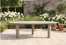 Familie geniet samen aan een houten tuintafel met comfortabele tuinstoelen en kleurrijke bloemen op een tuinset op het terras