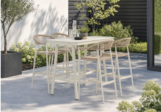 Moderne aluminium bartafel met vier hoge tuinstoelen op een terras, stijlvolle bistro tuinset tegen een houten wand