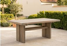 Moderne rechthoekige tuintafel met aluminium frame en houten tafelblad op een terras met loungese