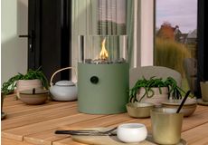 Sfeervolle buitentafel gedekt voor diner met lantaarnhaard, servies en warme verlichting in de tuin