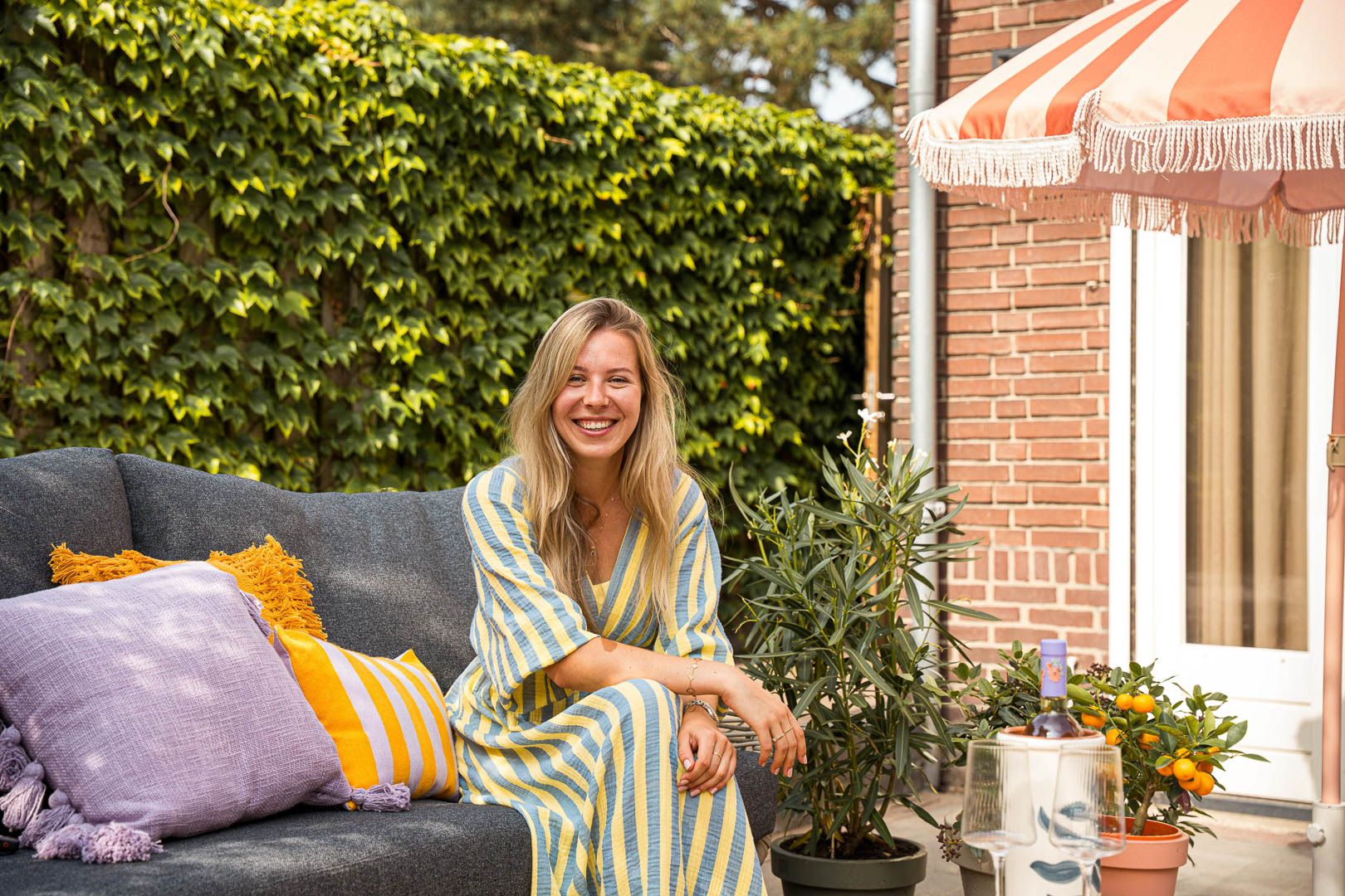 Styliste Hannah in een Bohemian tuin op een loungeset
