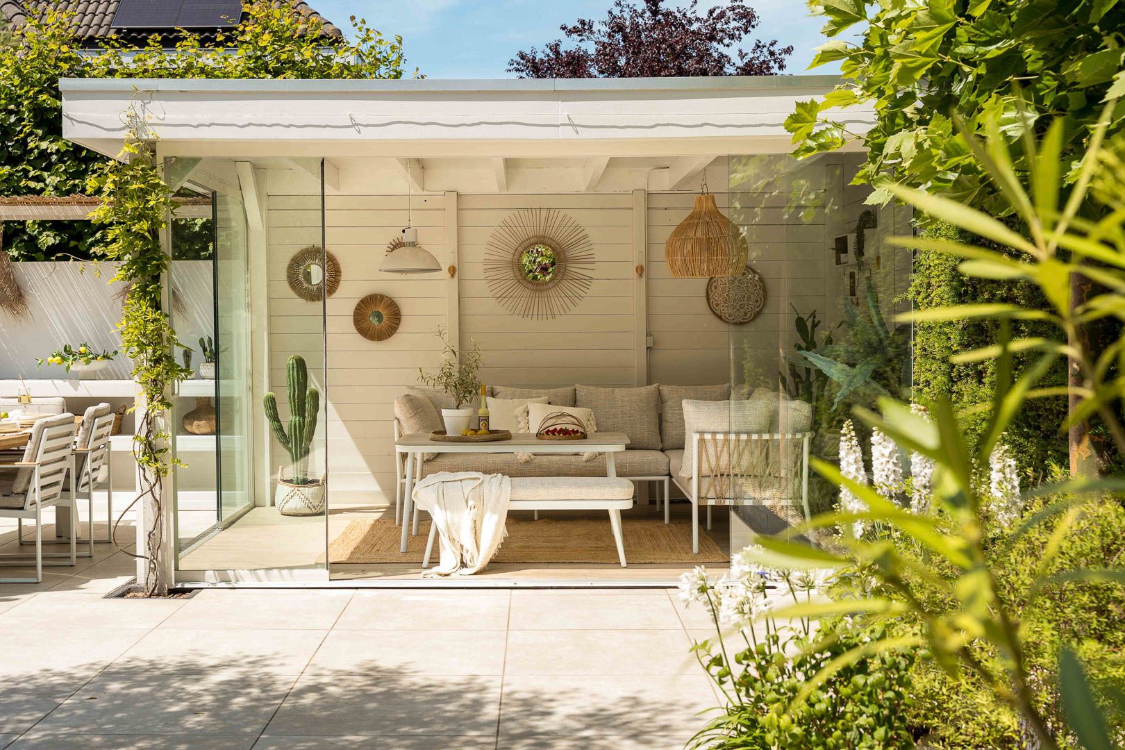 Ibiza tuin met lichte meubels en ontspannen sfeer