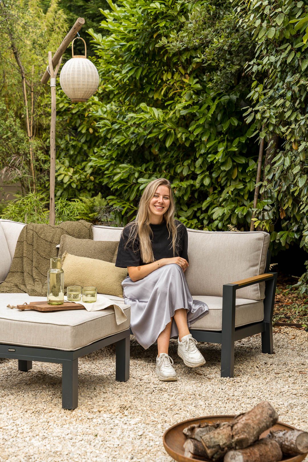 Styliste Hannah in een industriële tuin op een loungeset