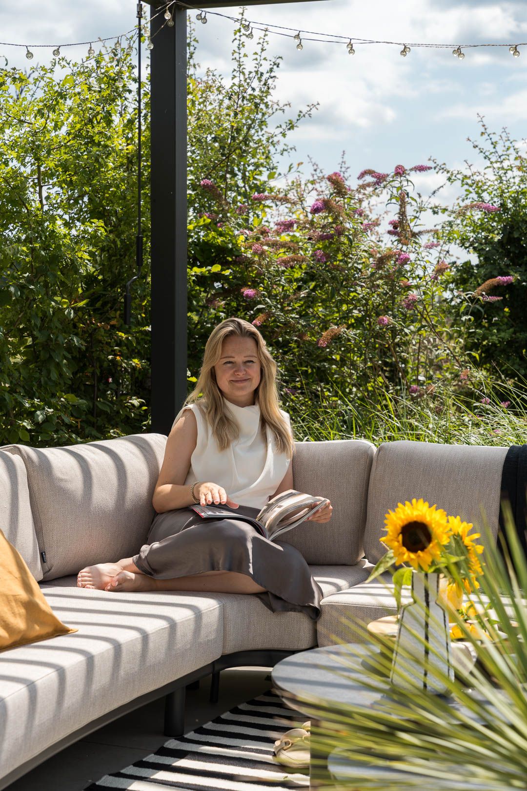 Lezen op een moderne loungeset onder een pergola