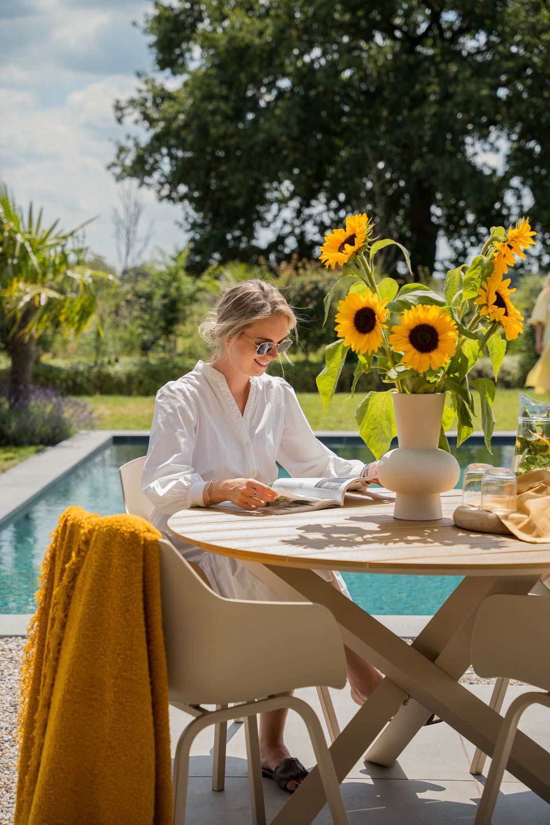 Lezen aan een tuinset aan het water in moderne stijl
